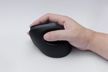 A side view of a human hand gripping an ergonomic vertical mouse on a white background, designed to reduce wrist strain and improve posture