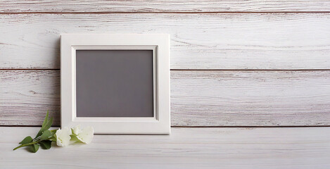 White photo frame on white wooden background. Empty space for text
