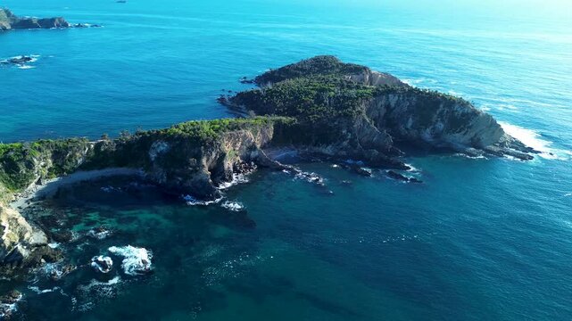Drone aerial landscape of bushland headland cliffs covered with trees overlooking rocky ocean inlet and beach cove along Malua Bay reef coastline in South Coast NSW Australia travel tourism and nature