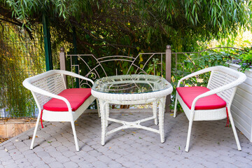 Obraz premium Outdoor wicker furniture with cushions in garden
