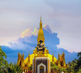 Statue of the king who built it in front of the Great Stupa Pha That Luang (the national symbol of Laos) in downtown Vientiane, Laos