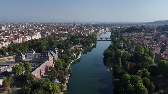 Aerial view of the Fiume Po flowing through the city, with bridges and lush green trees contrasting with the urban landscape, Turin, Piedmont, Italy.