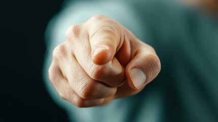 A close-up shot of a hand pointing assertively against a dark background, conveying a strong sense of direction and command, embodying human emotion and assertiveness.