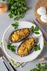 Stuffed eggplant baked with cheese and garlic on white plate, Top view