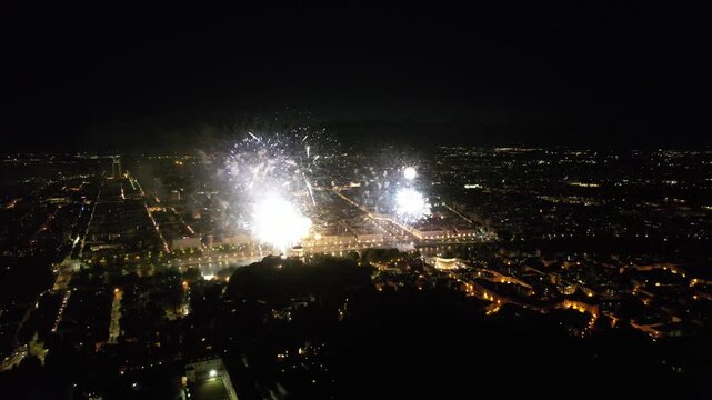 Aerial view of fireworks exploding over the Mole Antonelliana and city lights, illuminating the night sky with a dazzling display of light, Torino, Piemonte, Italy.