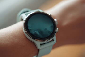 wearable smartwatch on human wrist with dark inactive display, minimalist technology accessory photographed indoors with shallow depth, modern lifestyle scene, concept of mental health tech