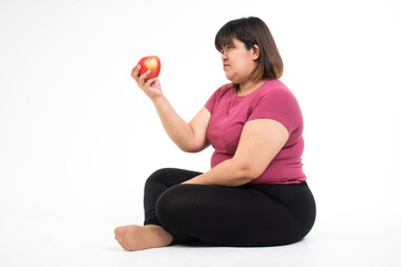 Contemplating the Apple: A person, seated, examines a vibrant red apple with curiosity, symbolizing healthy eating and a conscious lifestyle.
