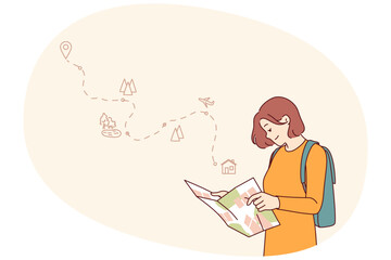 Woman tourist uses paper map to travel through nature reserves and plot route to destination. Smiling girl traveler plans tour route and chooses natural attractions worthy of visiting