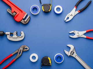 Professional plumbing tools on blue background house maintenance repair service advertisement background copy space equipment wrench pipe cutter