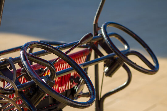 Close-up of multiple black steering wheels on a recreational tourist quadricycle pedal car