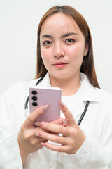 Portrait of young Asian female doctor against white background using phone