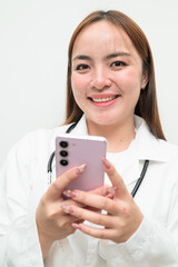 Portrait of young Asian female doctor against white background using phone