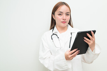 Portrait of young Asian female doctor against white background using tablet computer