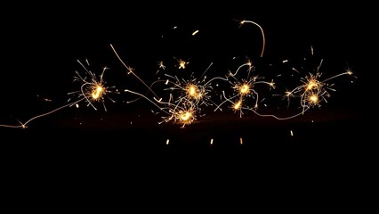 Bright golden sparkler trails and light painting on a black background for New Year celebration or event