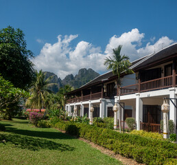 Traditional houses in the  resort city of Vang Vieng with its iconic towring karts mountains in the background, Vientiane Province, Laos