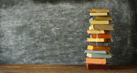 Stack of books with school blackboard. Education,back to school, knowledge is power concept. Free copy space.
