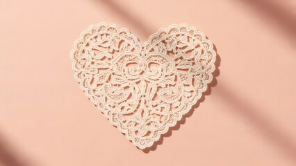 Delicate crocheted heart on a soft pink background casting a gentle shadow