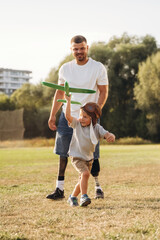 Obraz premium Active, running with toy plane. The amputee father is with his son on the field