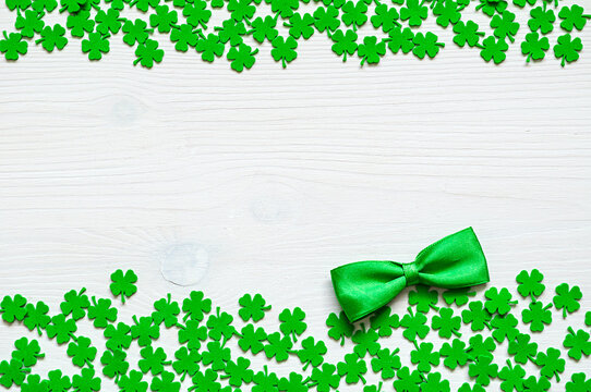 St Patrick's Day background, double border made of green artificial quatrefoils and a green sild bow tie, cope space for text