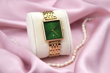 Closeup minimal fashion wristwatch for women on pink background.