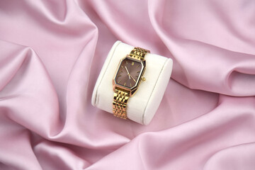 Closeup minimal fashion wristwatch for women on pink background.