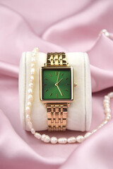 Closeup minimal fashion wristwatch for women on pink background.