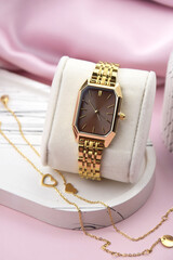 Closeup minimal fashion wristwatch for women on pink background.