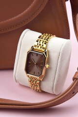 Closeup minimal fashion wristwatch for women on pink background.