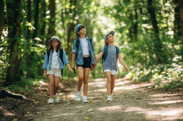 Going by the path. Girls kids are in the forest, hike conception