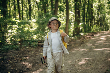 Cute little boy hiker is in the forest