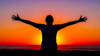 A silhouette of a woman standing on a summer beach at sunset with arms raised in joy and freedom as sunlight glows over the sea