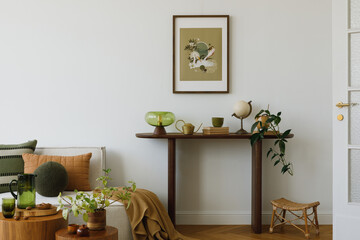 Botanical set up in living room with mock up poster frame, plants, lamp and wooden shelf. 