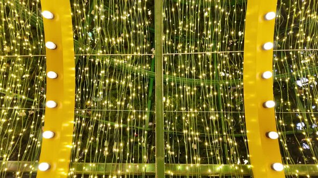 Camera video of golden holiday lights glowing in rows
