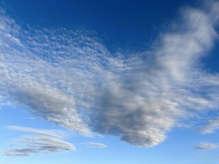 澄み渡る青空に広がる白いレンズ雲の風景 独特な形状の雲が美しい晴天の空模様 自然の美しさと開放感を感じさせる爽やかなバックグラウンド素材 気象や天気の変化を表現した大気のイメージ