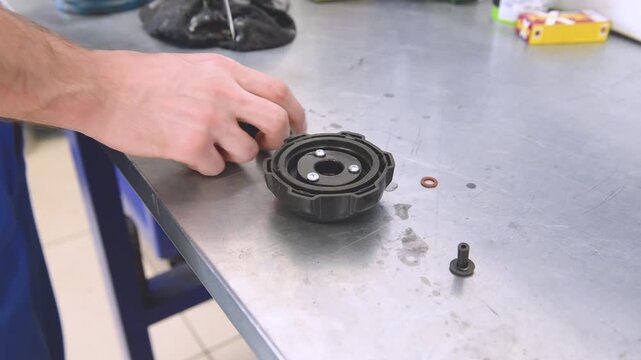 Service of the fuel cap oService of the fuel cap of the outboard motor. Repairing engines on boats , The technician is performs maintenance on a boat motor before the season.f the outboard motor