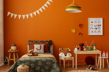 Children room with warm orange walls, woodland artwork and cozy bedding styled with playful forest-themed decor. © FollowTheFlow