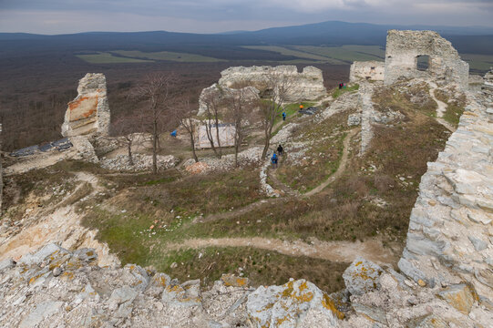 Aerial view of the stark white ruins of Gymes Castle stand in stark contrast against the muted forest and overcast sky, Jelenec, Nitra Region, Slovakia.