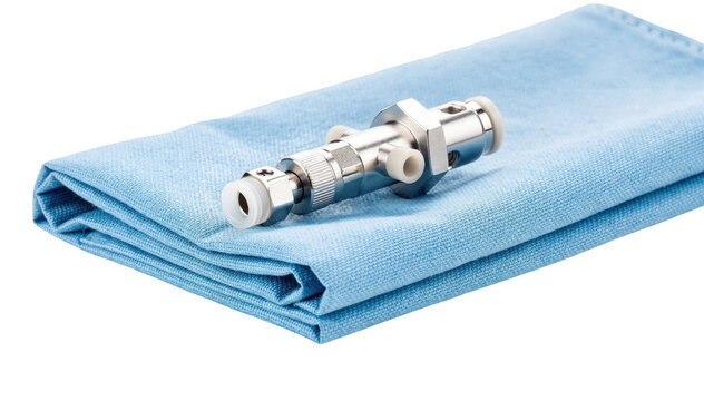 Closeup of a single valve shunt component on blue drape highlighting intricate design and function set against clean white background for clarity in medical explanation.