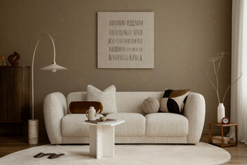 Neutral living room with soft beige sofa, graphic cushion, minimal decor and warm textured wall,...