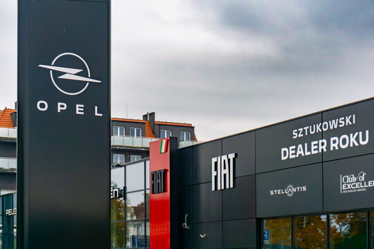 Opel and Fiat car dealership with brand pylon and black facade in urban industrial commercial zone