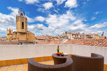 Rooftop terrace with view of Saint Sauveur Cathedral and tiled roofs in Aix en Provence, France, under a cloudy sky