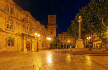 Fototapeta premium Illuminated Place de lHotel de Ville and clock tower at night in Aix en Provence, France, with historical architecture