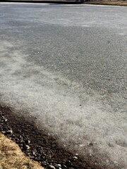 Obraz premium Serene Coastal Scene, Tranquil Shoreline With Rocks, Calm Rocky Beach With Sparse Vegetation, Gentle Ice Boundary Meets Pebble Bank Amidst Dormant Plants Under Muted Overcast Sky