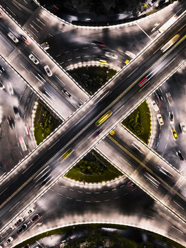 Aerial view of a glowing roundabout illuminated by car headlights and streetlights creates a dynamic, abstract pattern, Guangzhou, Guangzhou, China.