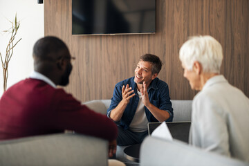 Friendly Business Meeting In Modern Office Lounge With Laughter And Engagement