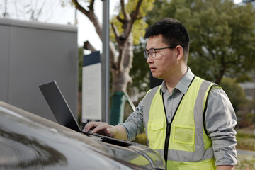 Fototapeta premium asian Worker uses laptop at charging station
