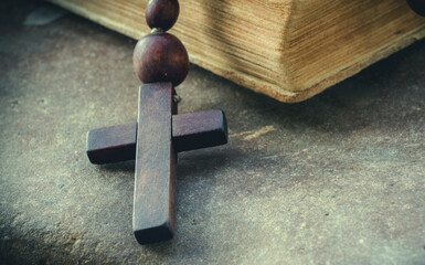 Rosary and Bible. Selactive focus on cross. Christianity, religion, faith concept Close up. Horizontal image..