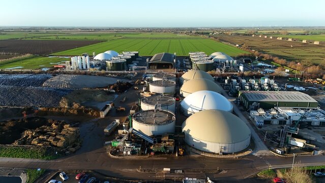 Aerial view of the sprawling energy plant, its colossal tanks and silver silos gleaming under the winter sun, amid the patchwork fields, Wisbech, England, United Kingdom.
