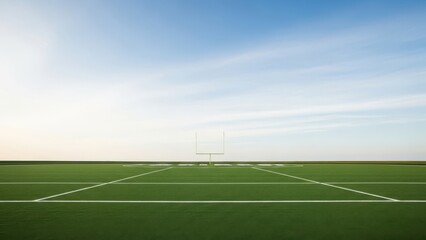 Fototapeta premium A serene American football field under a clear blue sky with white goalposts and green turf