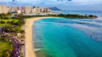 Aerial view of turquoise waters meeting golden sands near Ala Moana Park and the Waikiki skyline, framed by Diamond Head, Honolulu, Hawaii, United States.